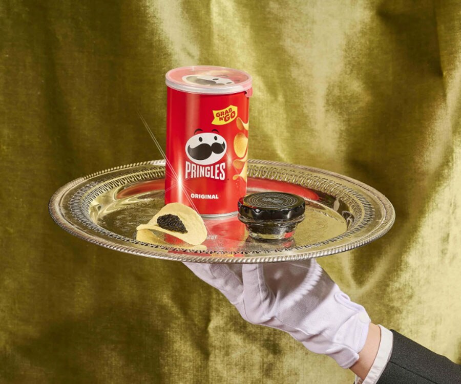 A can of Pringles on a serving plate with a dish of caviar