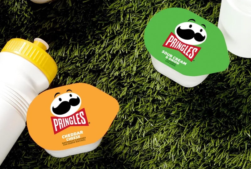 Pringles Snack size packages on grass with a sport water bottle.